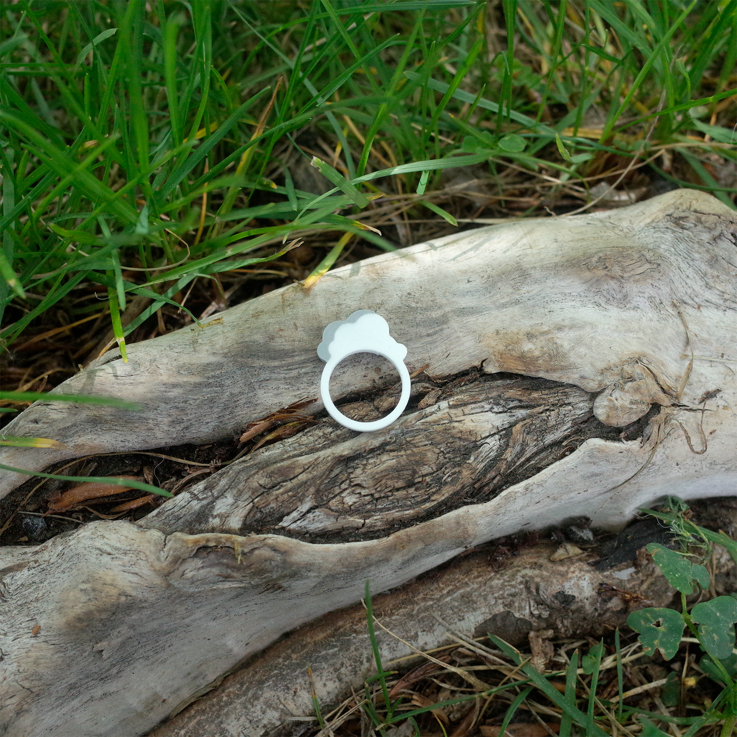 Another angle of the plain white cloud ring, highlighting the smooth, rounded shape on a wood surface.