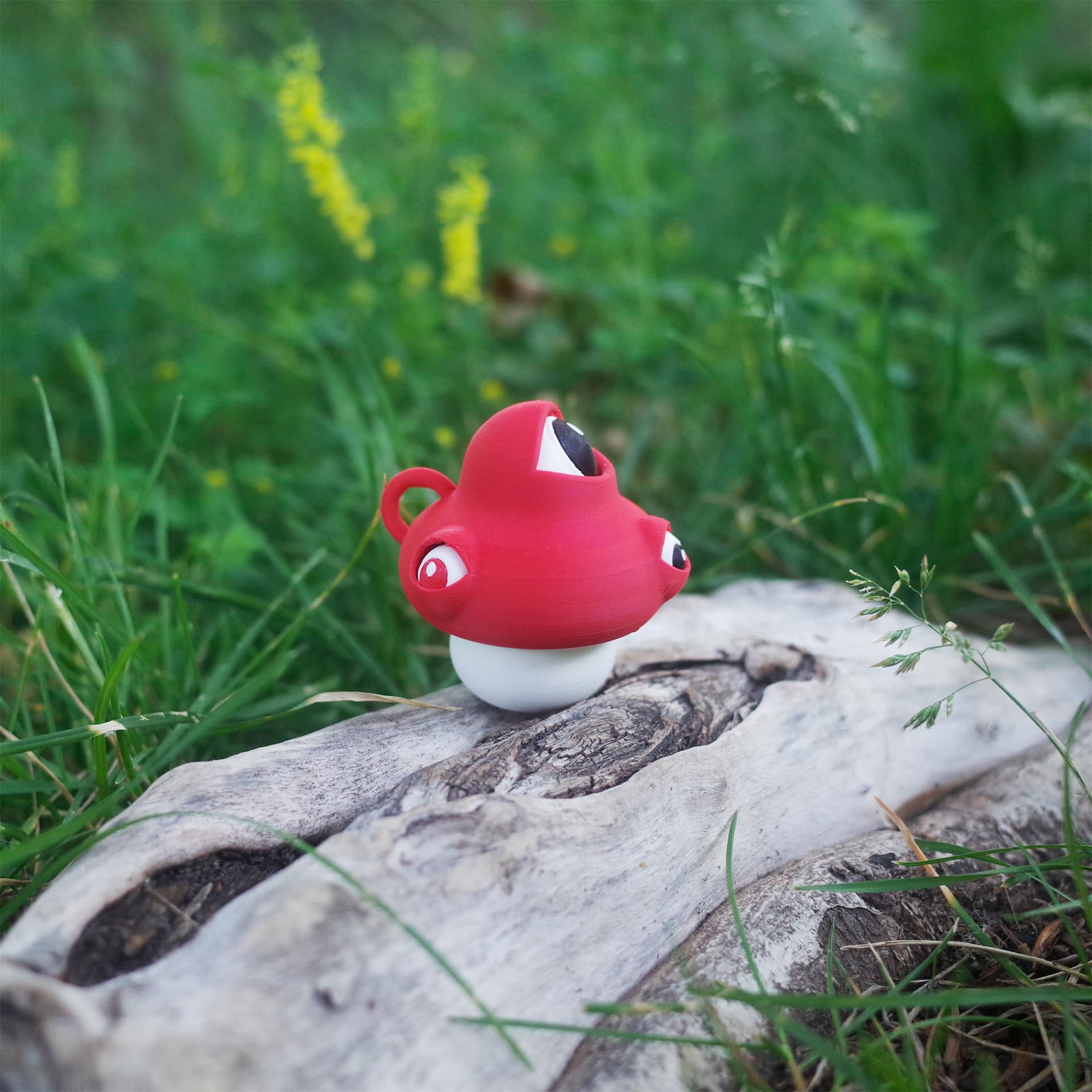 The Eyeball Mushroom posed on driftwood, appearing curious in a lush green setting.